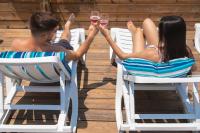  זוג בכיסאות שיזוף עם כוסות שמפניה - ספא דרים ביץ