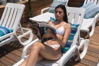   אורחת במיטת שיזוף קוראת עיתון - ספא דרים ביץ