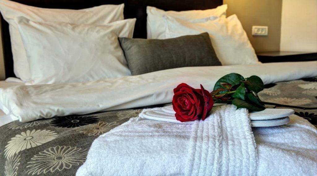   מיטה בחדר לינה העם חלוק וורד - ספא קרלטון סיטי נהריה