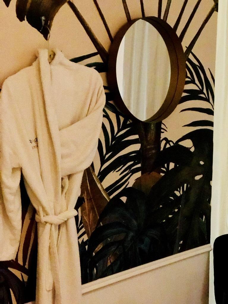   חלוק ומראה תלויים על הקיר - ספא לאוקסיטן